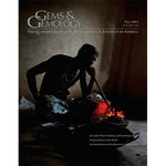 Cover of Gems & Gemology Fall 2014 issue, featuring man in cave blowing through tube onto fire