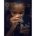 Cover of Gems & Gemology Summer 2014 issue, featuring woman gazing into gem identification tool